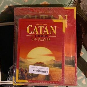 Catan board game plus extension pack.  New, never opened.